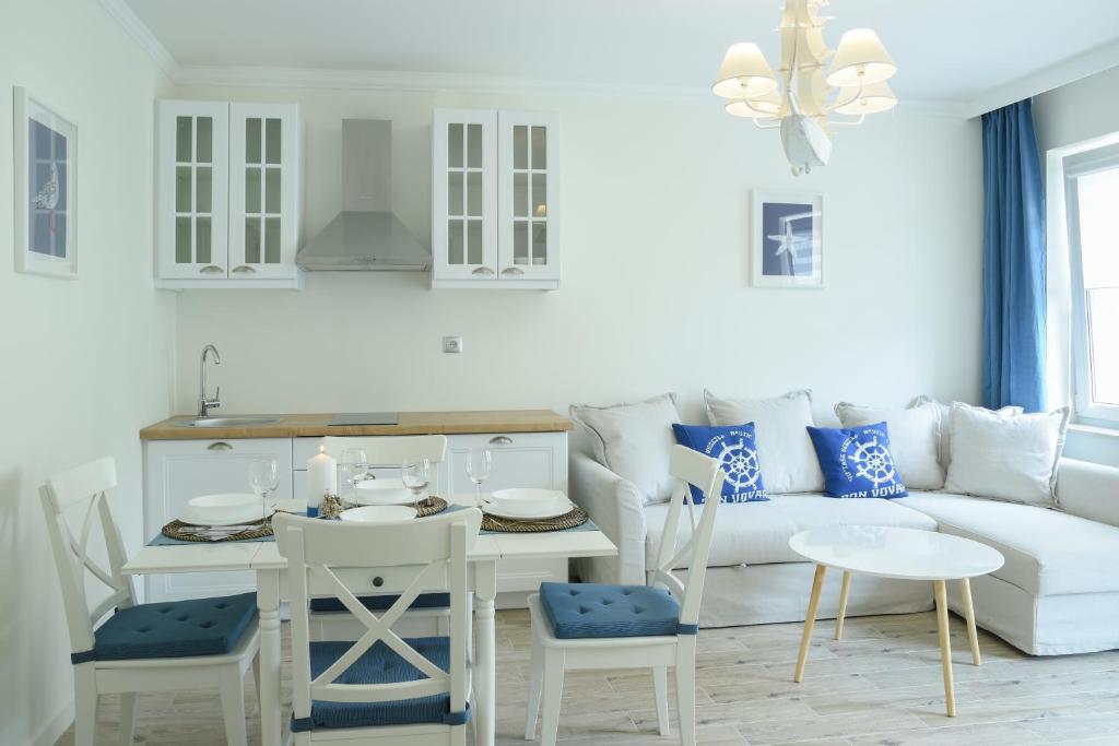 a white living room with a white couch and a table at Seaside Apartamenty Puck in Puck
