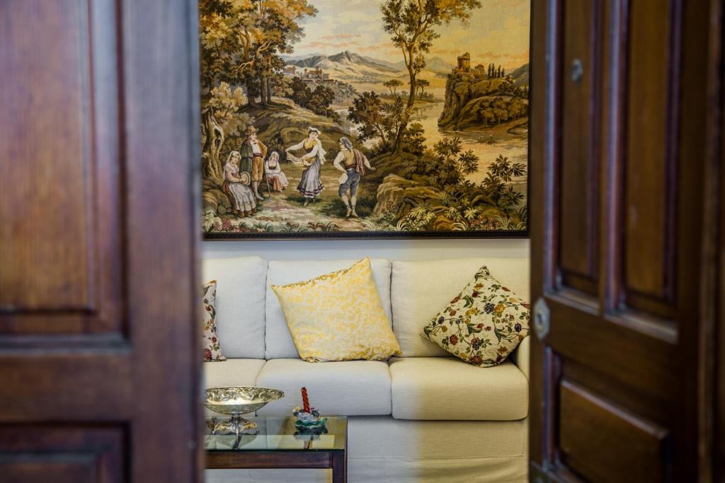un soggiorno con divano e un dipinto sul muro di BellAqua a Catania