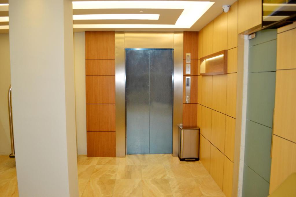 A lift lobby finished in light wood, stone-look flooring and bright recessed lighting.