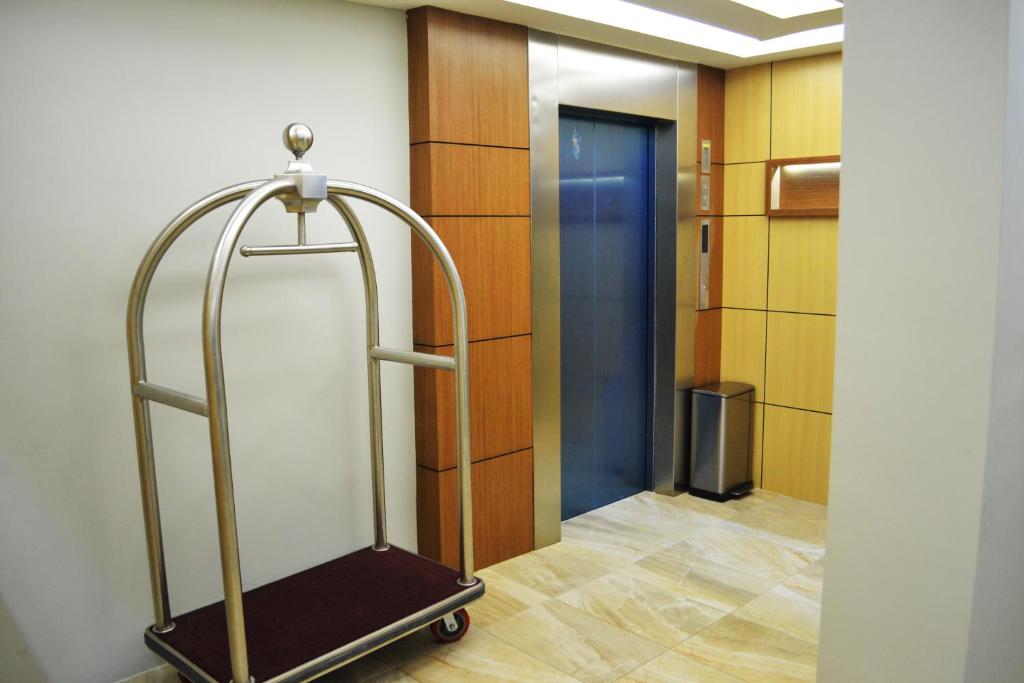 An elevator lobby with a brass luggage cart and warm wood-panelled walls.