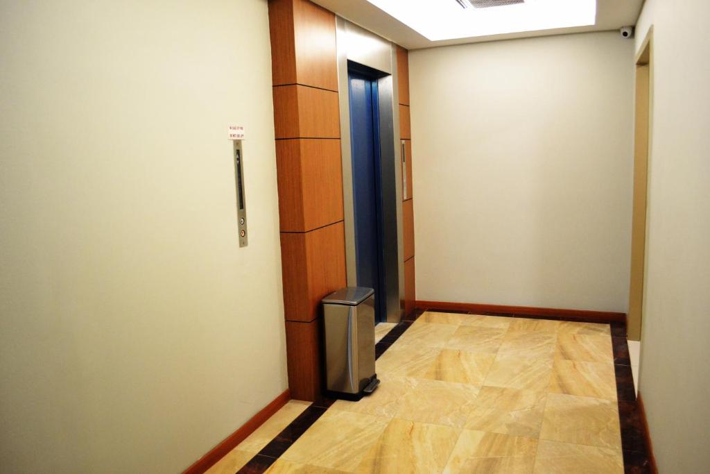 A quiet elevator landing with polished flooring and wood-trimmed lift surrounds.