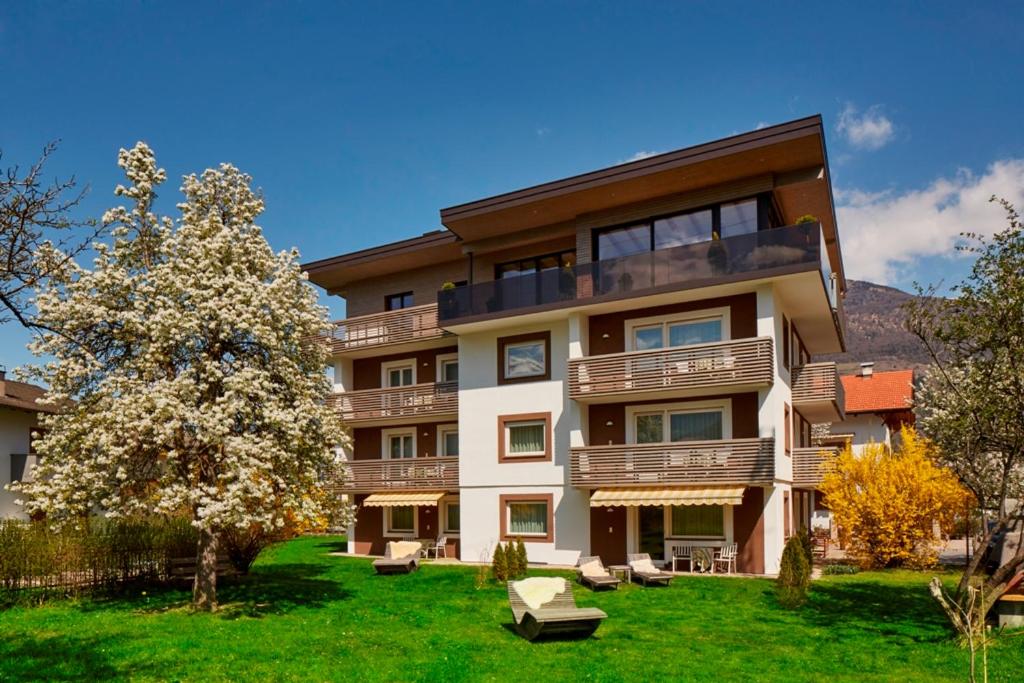 un gran edificio de apartamentos con un árbol en el patio en Residence Gustav Thoeni en Prato allo Stelvio