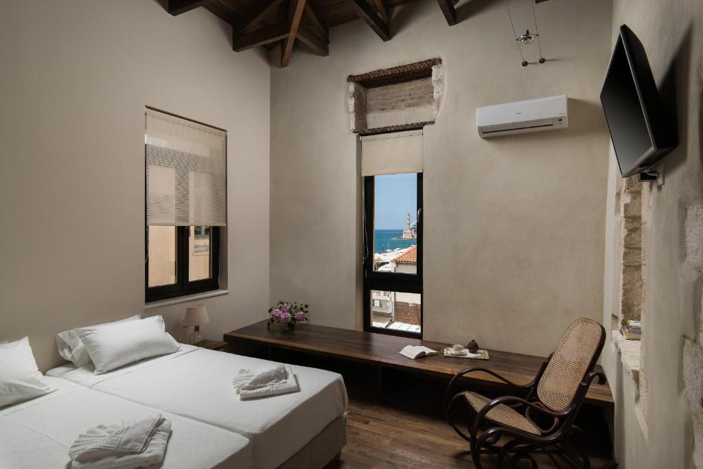 a bedroom with two beds and a desk and a window at Nonnalena Boutique Hotel in Chania Town