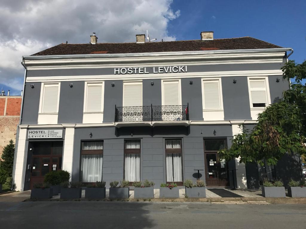 a white building with a hostel tavern sign on it at Hostel Levicki in Slavonski Brod