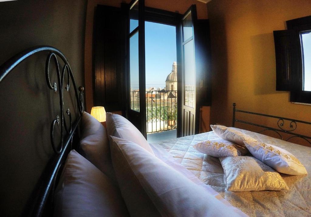 a bedroom with a bed with a view of the city at AltoBarocco House in Catania