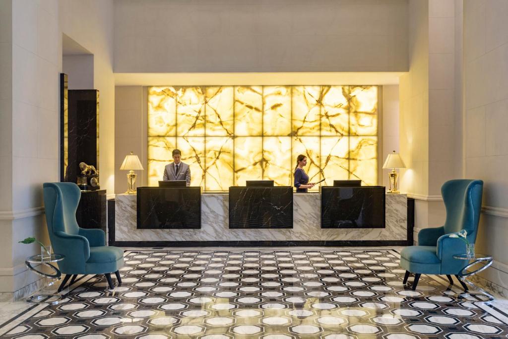 - un hall avec deux personnes assises sur un bureau dans l'établissement Alvear Icon Hotel, à Buenos Aires