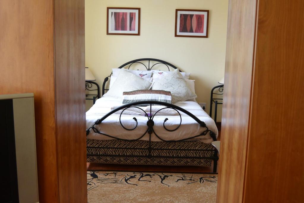a bedroom with a bed with white sheets and pillows at Natalie Guesthouse in Bloubergstrand