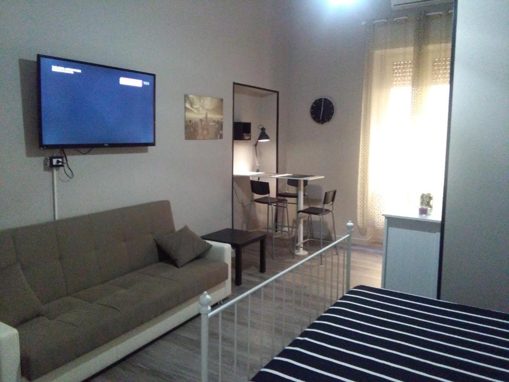 sala de estar con sofá y TV de pantalla plana en Meridional Station, en Nápoles