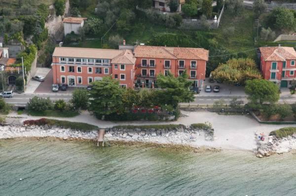 widok z powietrza na budynek obok wody w obiekcie Hotel Residence Sirenella w mieście Torri del Benaco