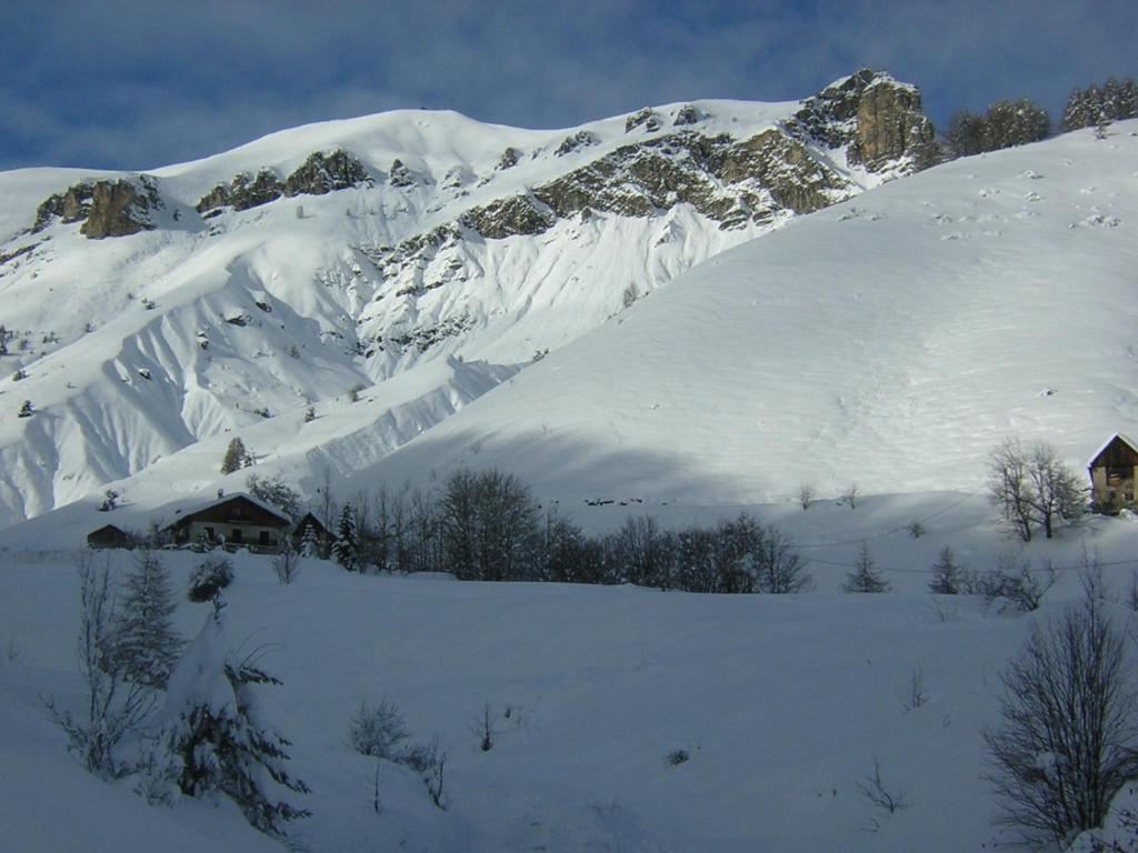 a snow covered mountain with a house in the foreground at Chalet Lou Bella Vista in Auron