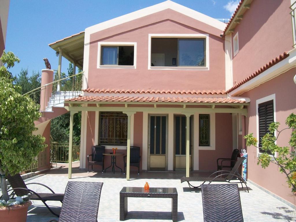a pink house with chairs and a table at Ramona in Lourdata