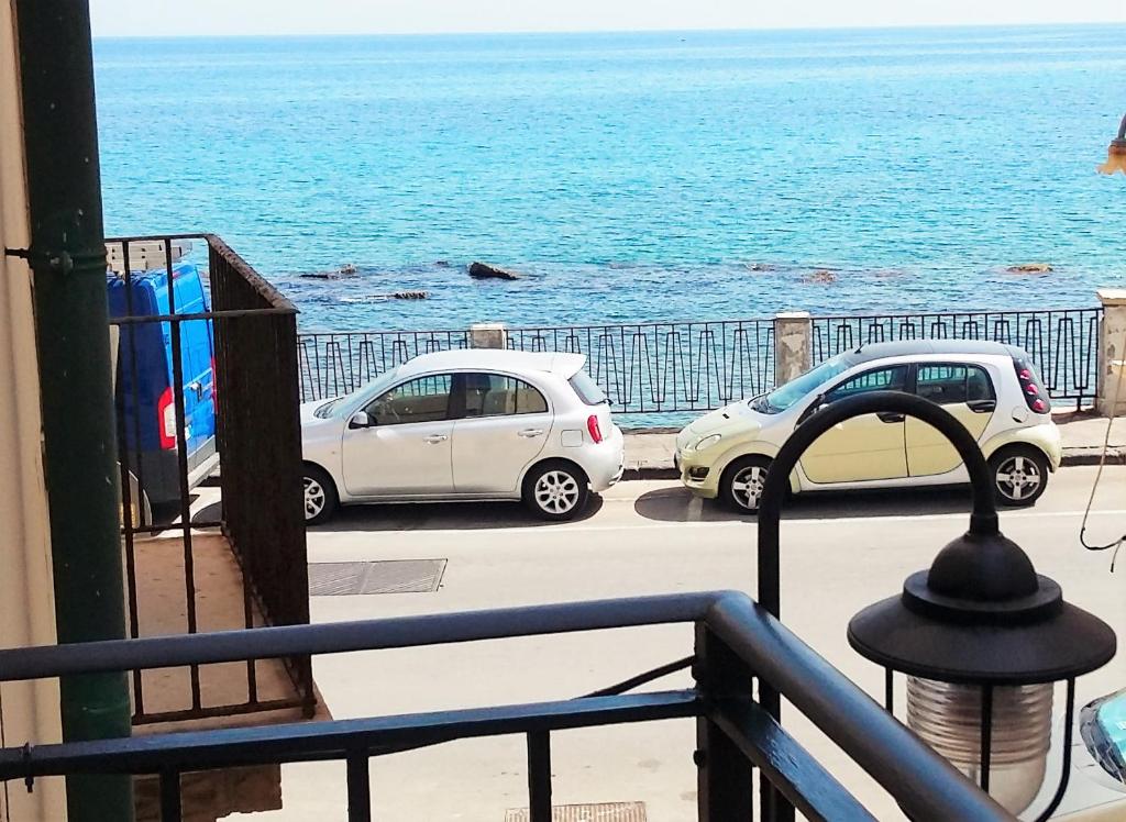 シラクーサにあるOrtigia Vista Mare - ortigiavistamareonwebitの海の近くのバルコニーに駐車した2台の車