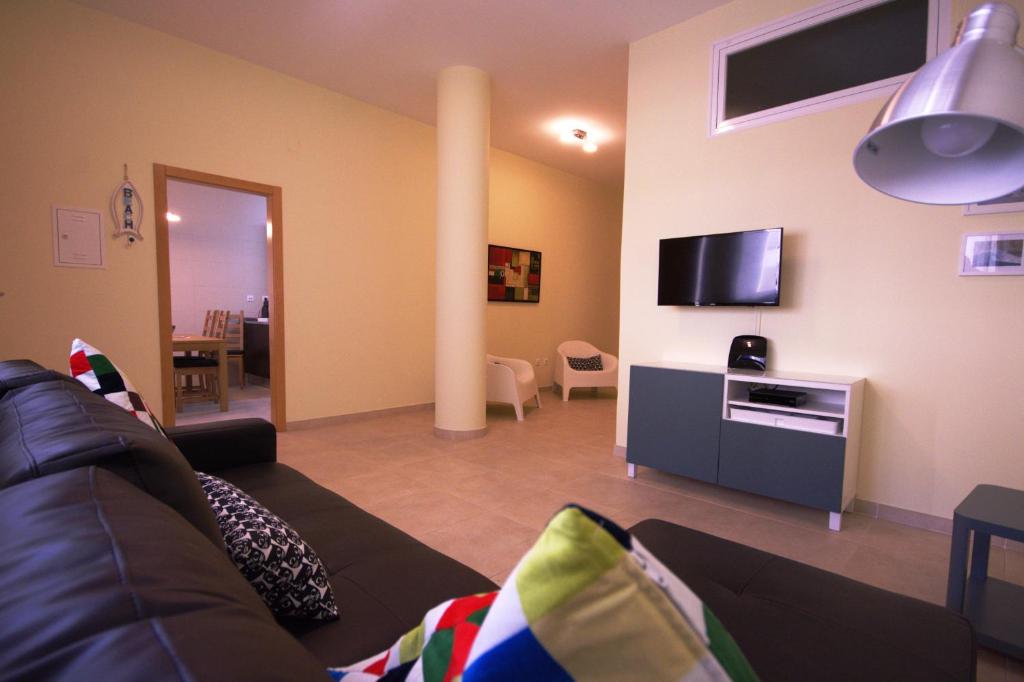 uma sala de estar com um sofá e uma televisão de ecrã plano em Apartamentos Plaza - Albufeira em Albufeira