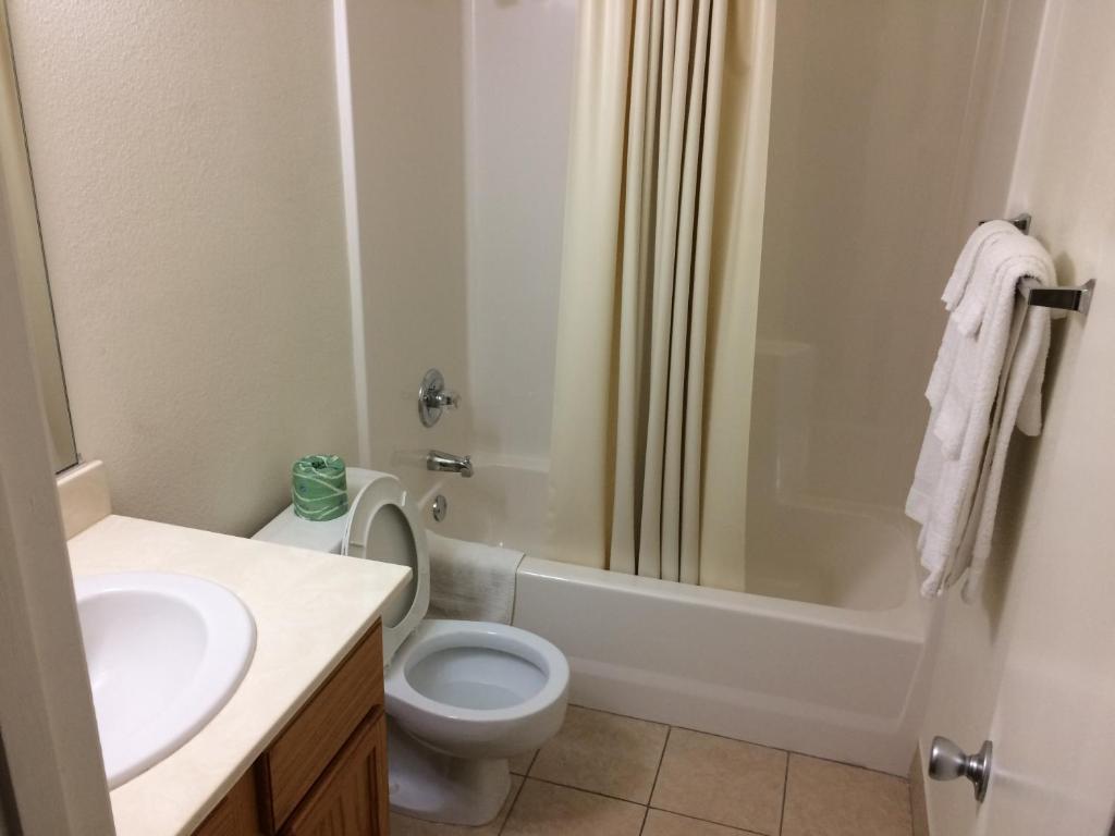 a bathroom with a toilet and a sink and a shower at Travel Inn & Suites in Atlanta