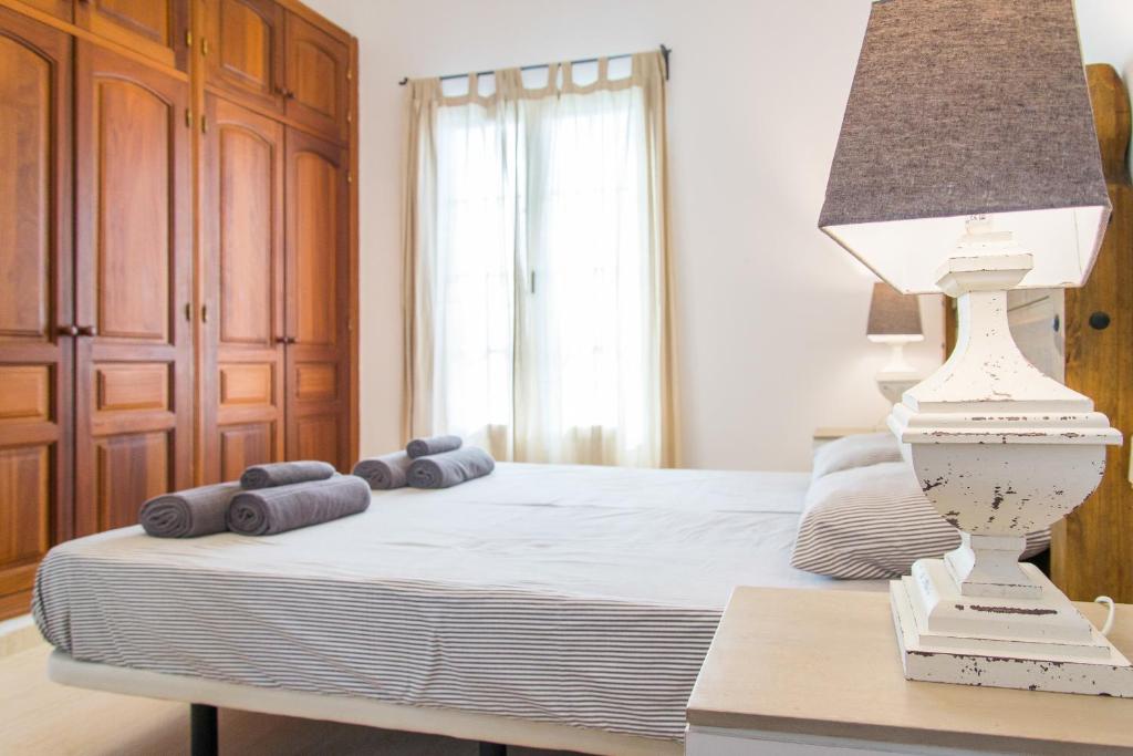 a bedroom with a bed and a table with a lamp at Villa Veronica in Corralejo