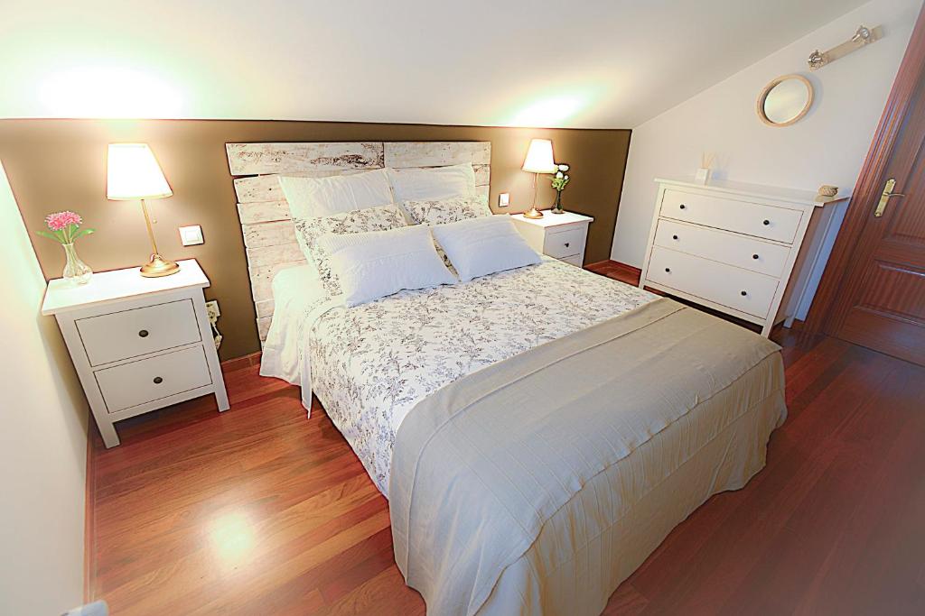 a bedroom with a large bed with two night stands at Chalet junto a playa de Suances in Suances