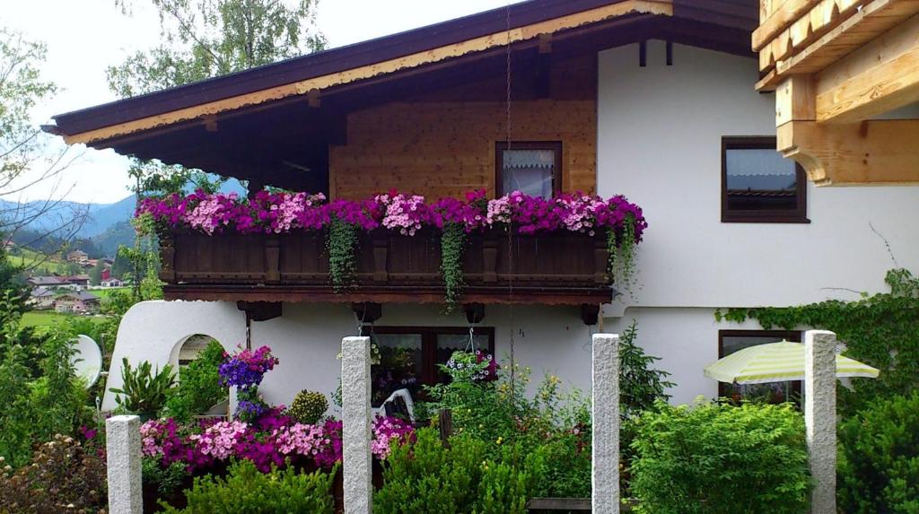 a white house with flowers on a balcony at Haus Alex in Achenkirch