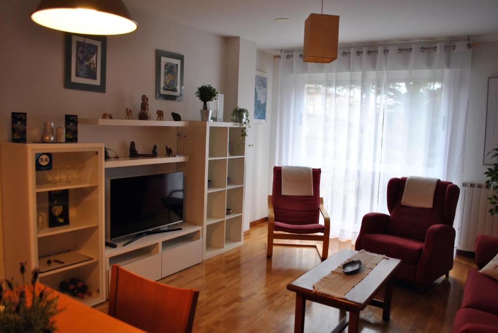 a living room with a tv and chairs and a table at El Parque Navajas in Fuenmayor