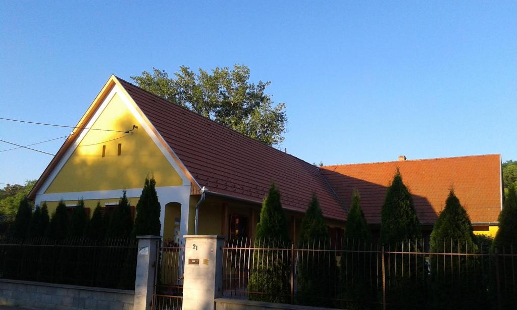 Biały dom z brązowym dachem i płotem w obiekcie Döröcske Vendégház w mieście Somogydöröcske