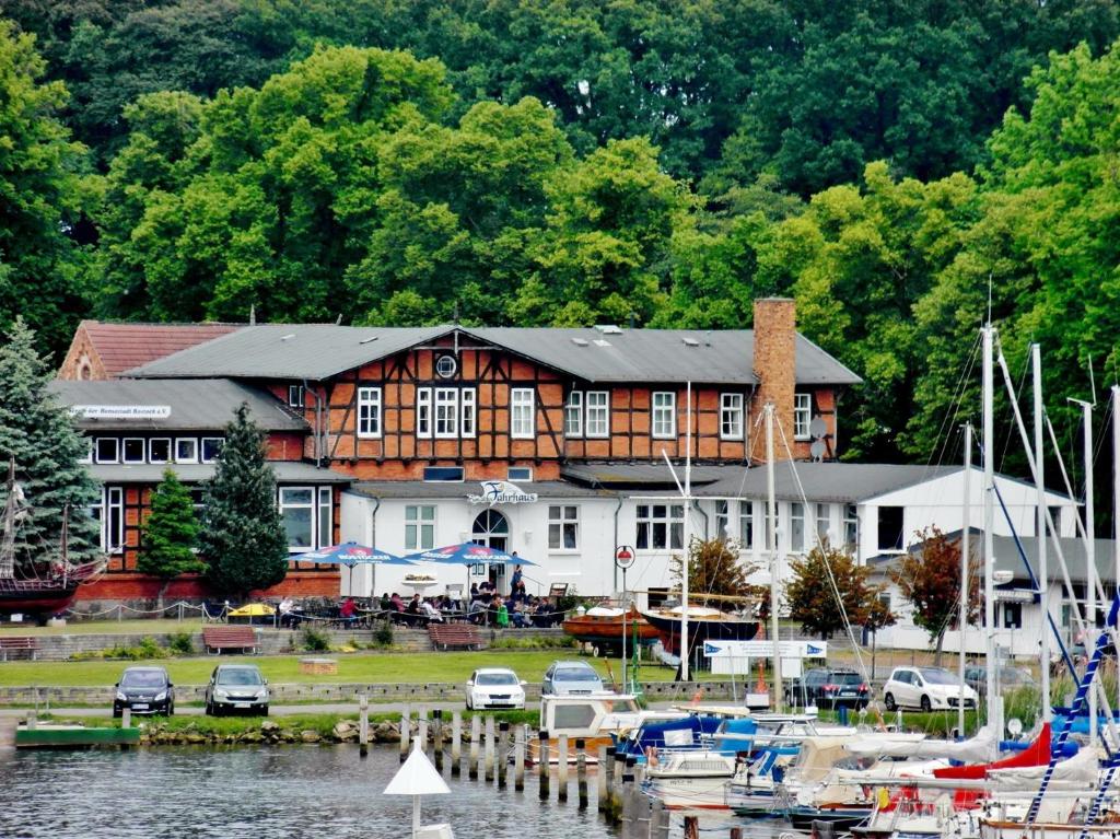 un grand bâtiment avec des bateaux amarrés dans un port de plaisance dans l'établissement Pension Zum Alten Fährhaus, à Rostock