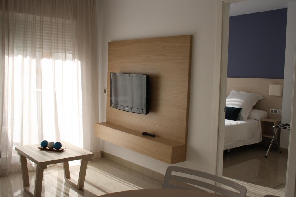 a living room with a television on a wall at Apartamentos Playa Barbate in Barbate