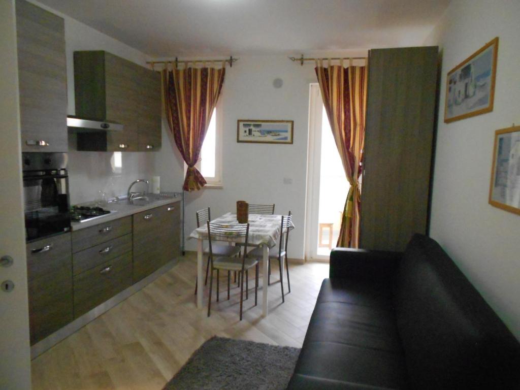 a living room with a kitchen and a table with chairs at country house prima casa in Francavilla al Mare