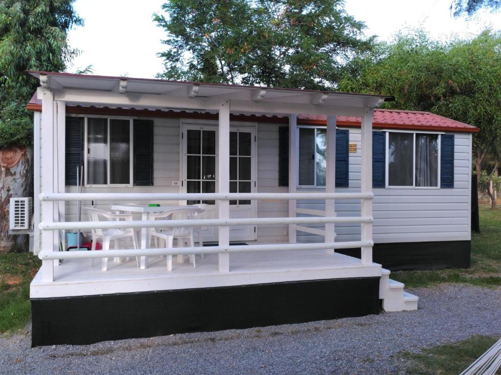a tiny house with a porch and a table at Campeggio Lao in Scalea