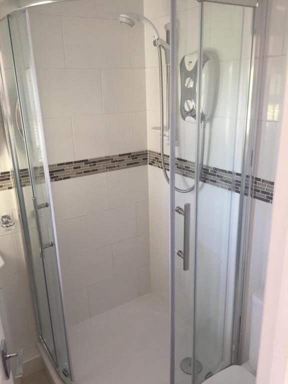 a shower with a glass door in a bathroom at The Retreat in Charmouth