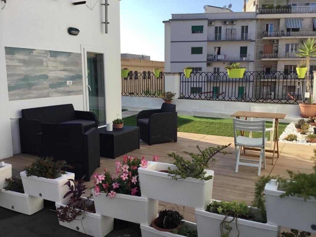 eine Terrasse mit Topfpflanzen und einem Tisch auf dem Balkon in der Unterkunft Monolocale "Villari" in Bari