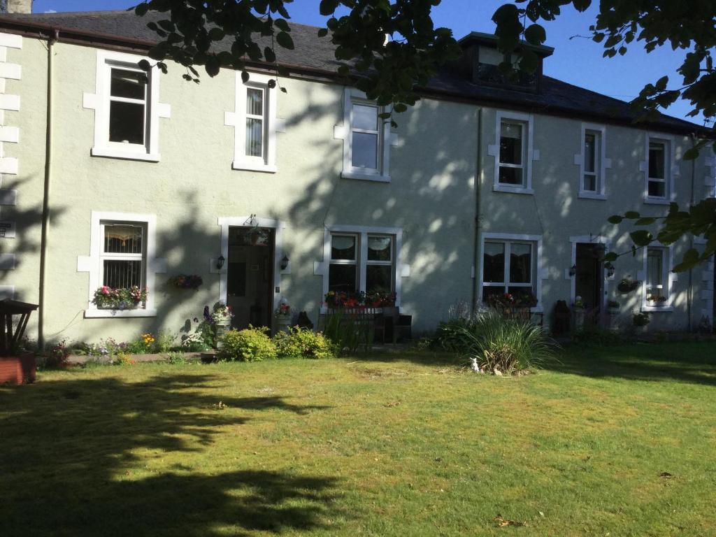 une maison blanche avec une cour devant elle dans l'établissement Inverlochy Villas (Adults Only), à Fort William