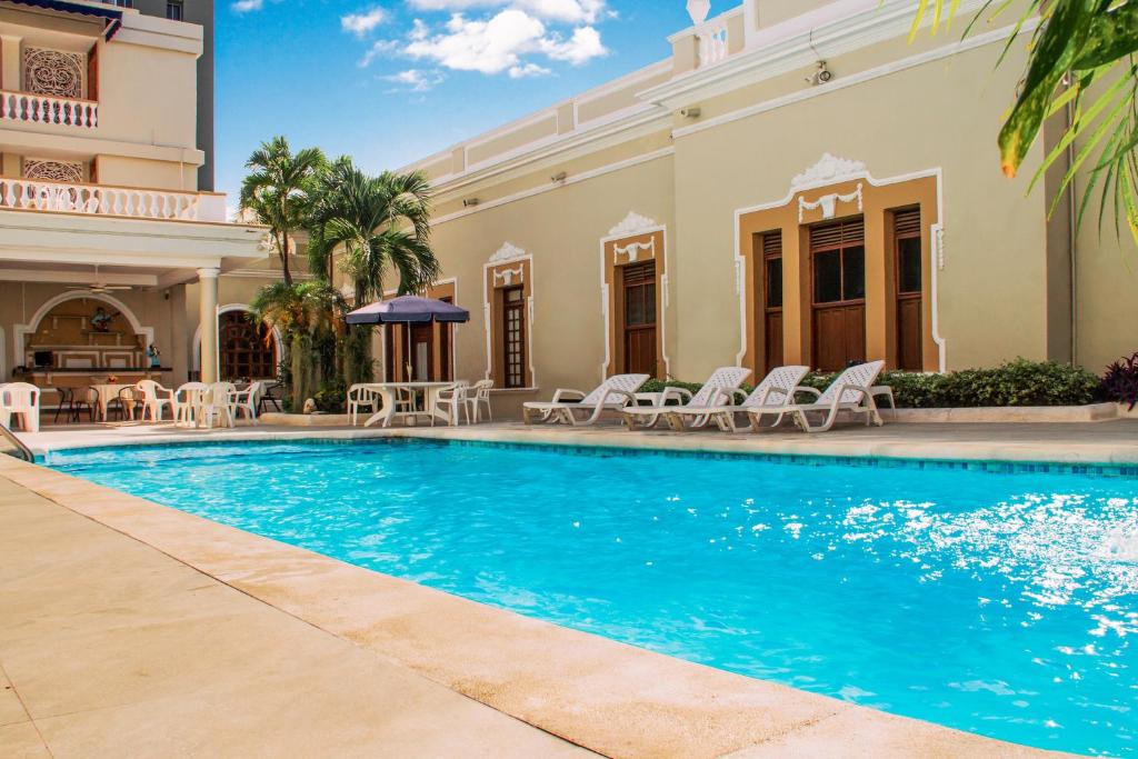 uma piscina em frente a uma casa em Hotel Majestic em Barranquilla
