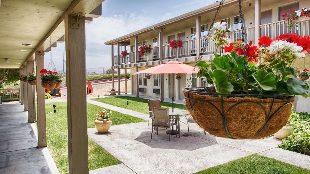 um pátio com uma mesa e flores num grande vaso em Best Western Marina State Beach em Marina