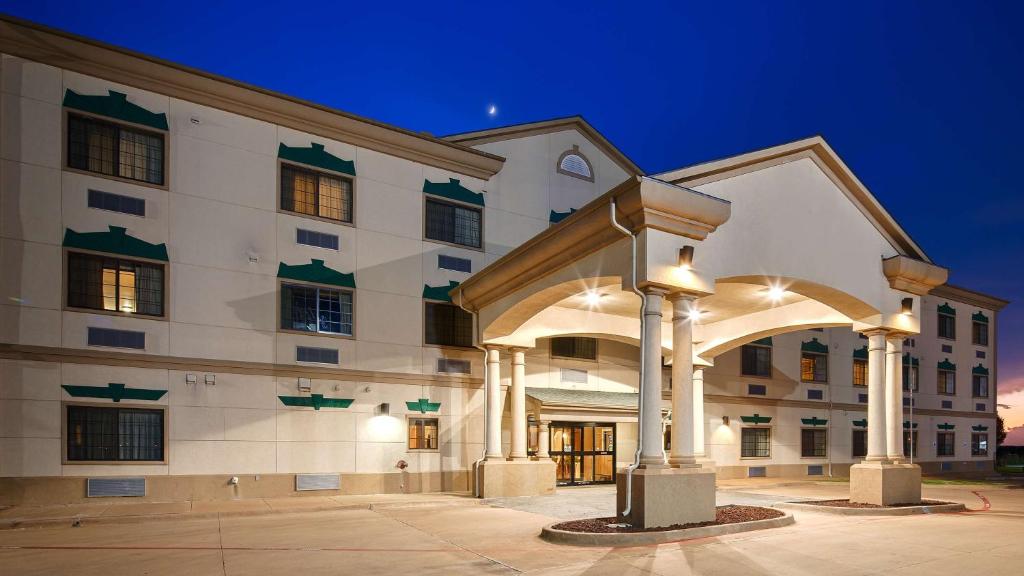 a large white building with an arch in front of it at Best Western Inn & Suites - Henrietta in Henrietta