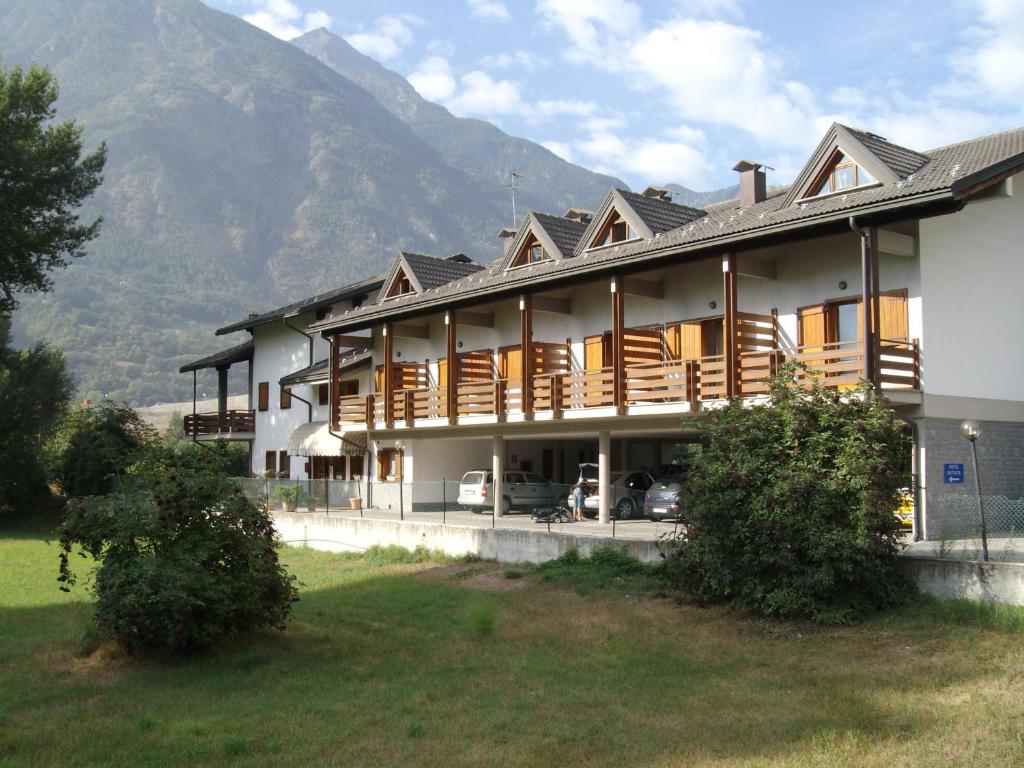 a large building with a mountain in the background at Hotel Petit Foyer in Aosta