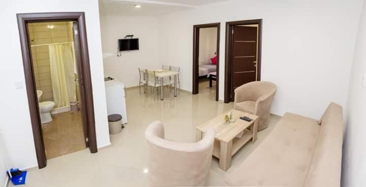 a living room with a couch and a table at Apartmani "ROSHU" in Soko Banja