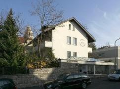 ein schwarzes Auto, das vor einem weißen Gebäude parkt in der Unterkunft Appart International Boarding House in Würzburg