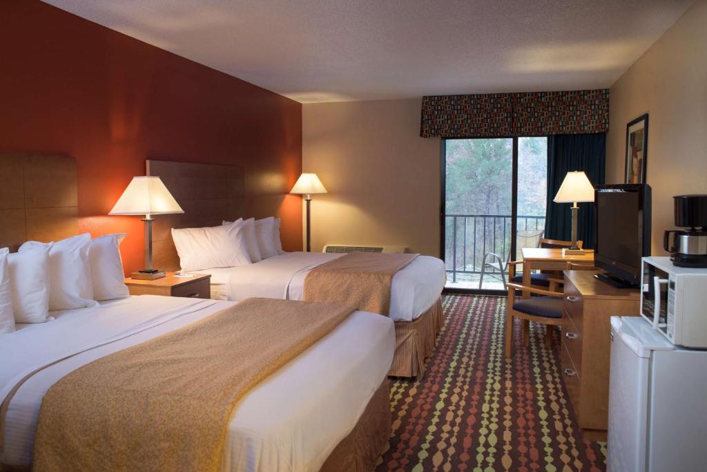 a hotel room with two beds and a television at Best Western Ambassador Inn & Suites in Wisconsin Dells
