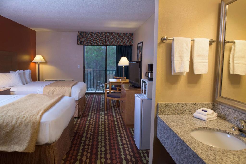a hotel room with two beds and a sink at Best Western Ambassador Inn & Suites in Wisconsin Dells