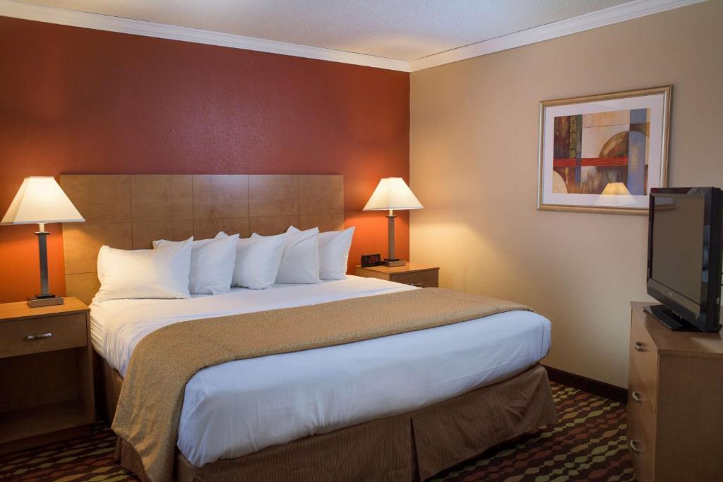 a hotel room with a large bed and a flat screen tv at Best Western Ambassador Inn & Suites in Wisconsin Dells
