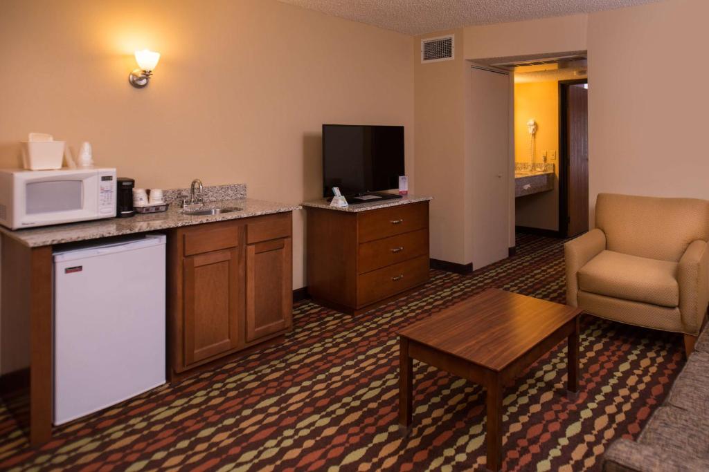 a hotel room with a kitchen and a microwave at Best Western Ambassador Inn & Suites in Wisconsin Dells