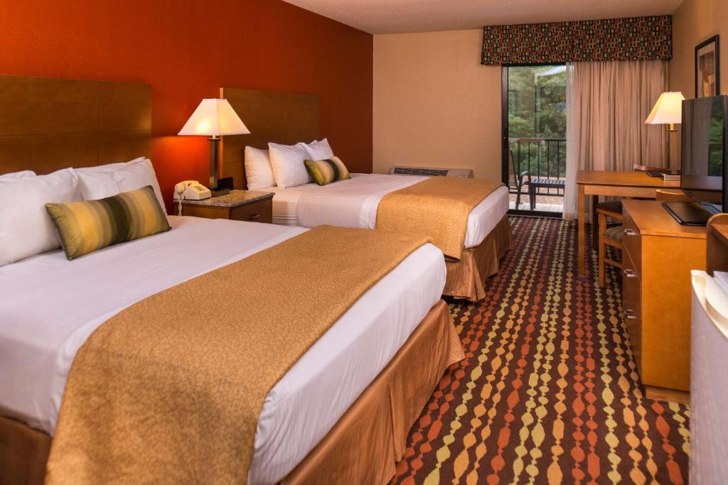 a hotel room with two beds and a television at Best Western Ambassador Inn & Suites in Wisconsin Dells