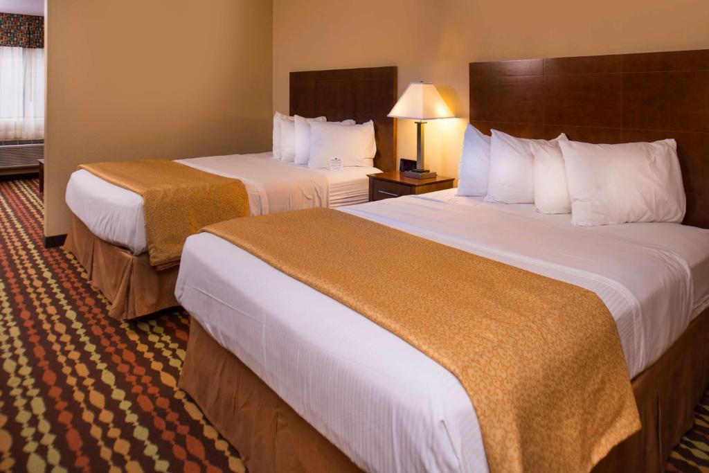 a hotel room with two beds and a lamp at Best Western Ambassador Inn & Suites in Wisconsin Dells