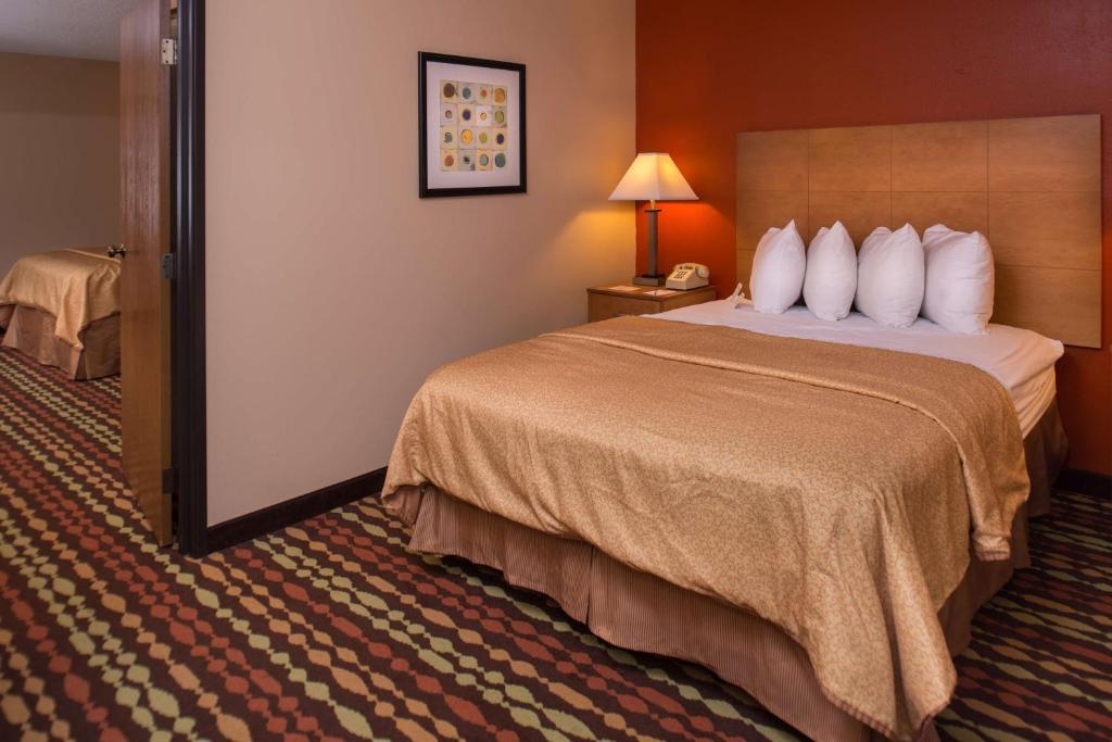 a hotel room with a bed and a lamp at Best Western Ambassador Inn & Suites in Wisconsin Dells