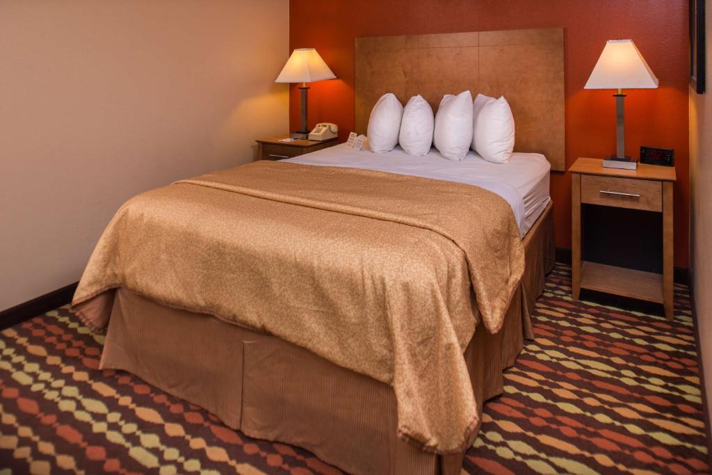 a hotel room with a bed and two lamps at Best Western Ambassador Inn & Suites in Wisconsin Dells