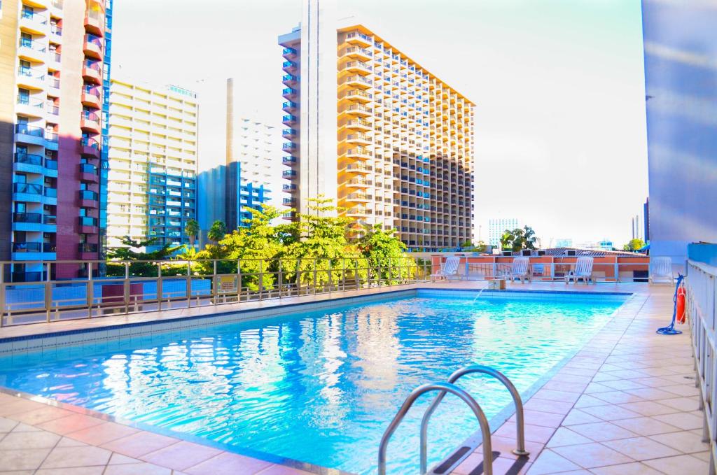 a swimming pool in a city with tall buildings at ABC Apart Hotel in Brasilia