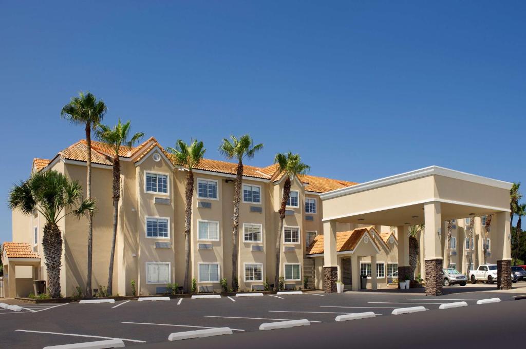 a large building with palm trees in a parking lot at Best Western Beachside Inn in South Padre Island