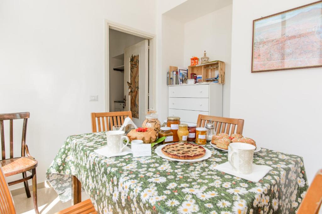 uma mesa com uma toalha de mesa com comida em B&B OTIUM em Pompeia