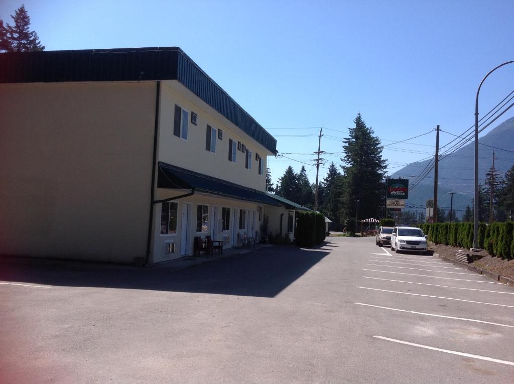 a building with a car parked in a parking lot at Coquihalla Motel in Hope