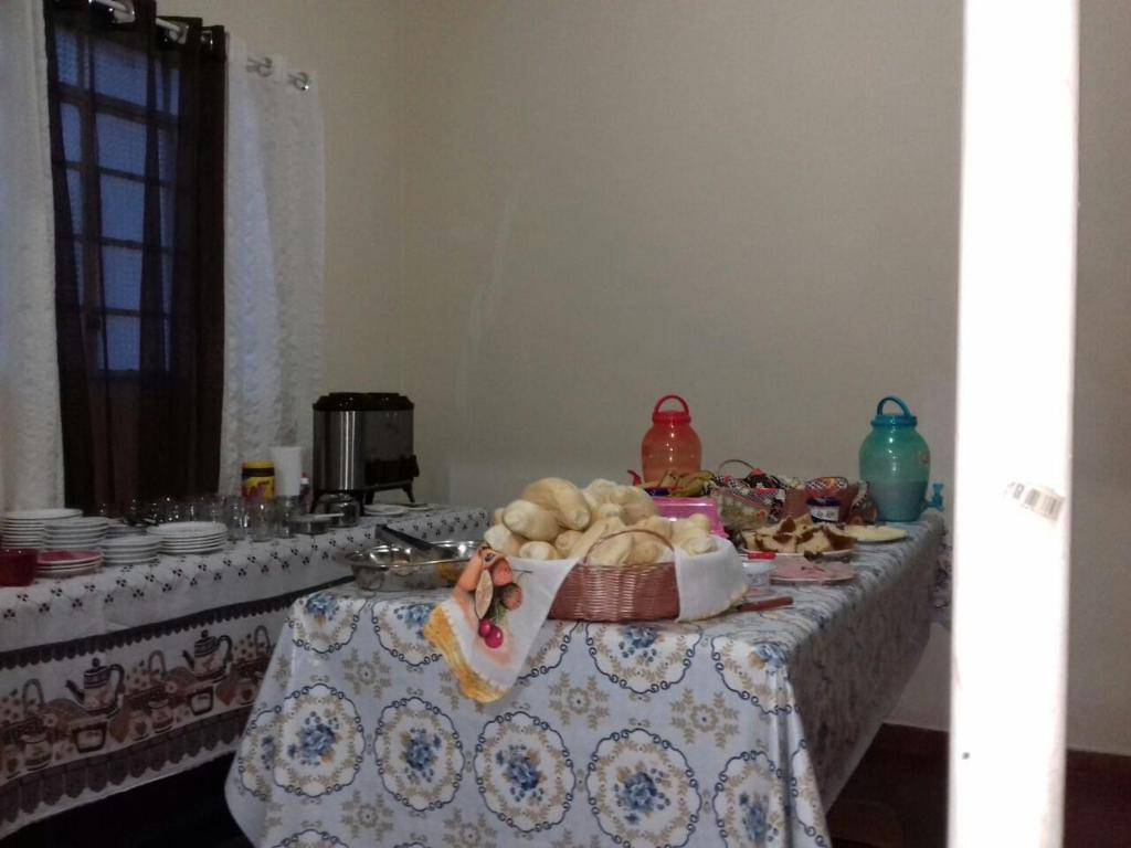 une table avec une assiette de nourriture dessus dans l'établissement Orquidea Hospedagem, à Cachoeira Paulista