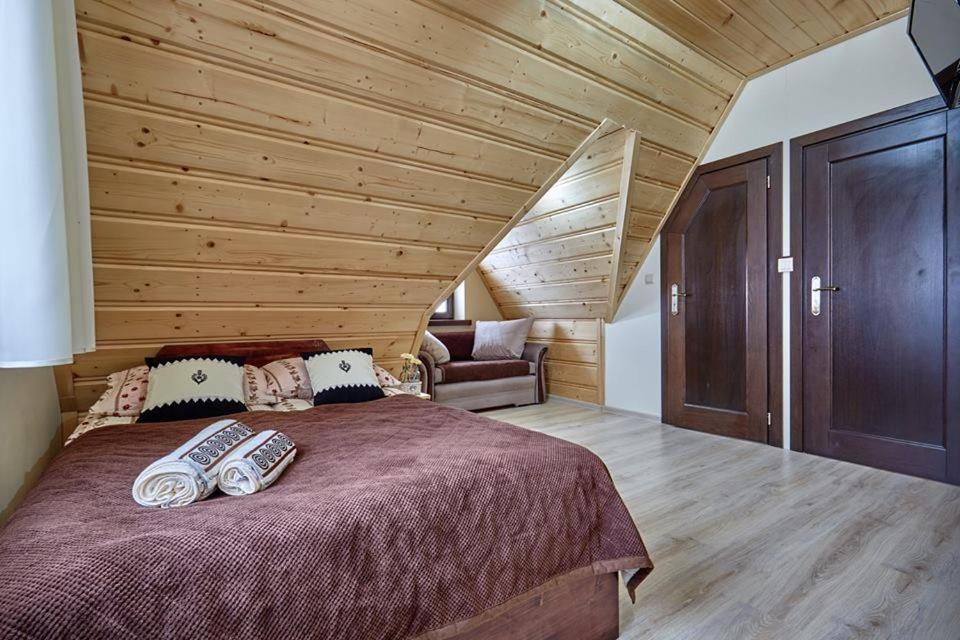 een slaapkamer met een groot bed met een houten plafond bij Aga in Suche